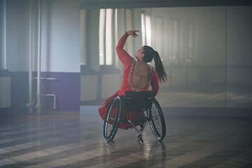 Woman with a disability, a para dancer practicing choreography at the dance studio, making...