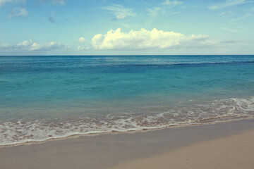 Tropical paradise beach with white sand and clouds sky.