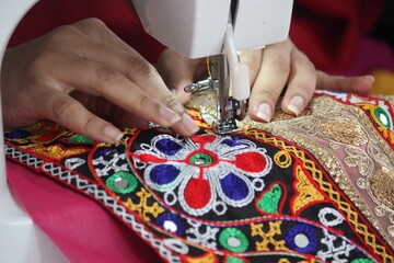 stitching machine closeup for sewing the floral design traditional navratri laces for chaniya...