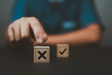 Hand push red Red Cross mark to choose cancellation item , Approve and reject business and document...