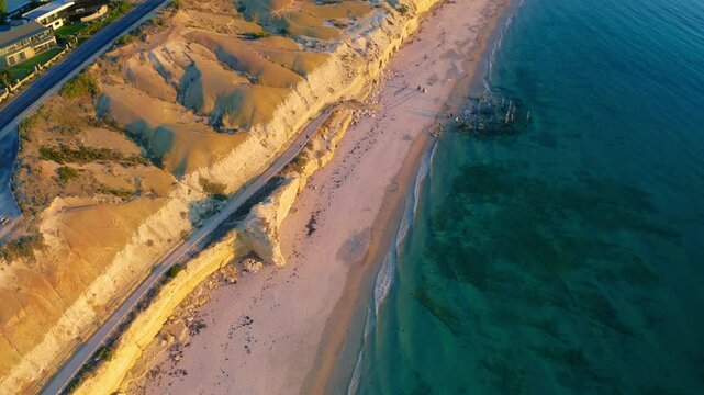 Aerial view of cliffs and beach at sunset overlooking the ocean, Port Willunga, Australia.