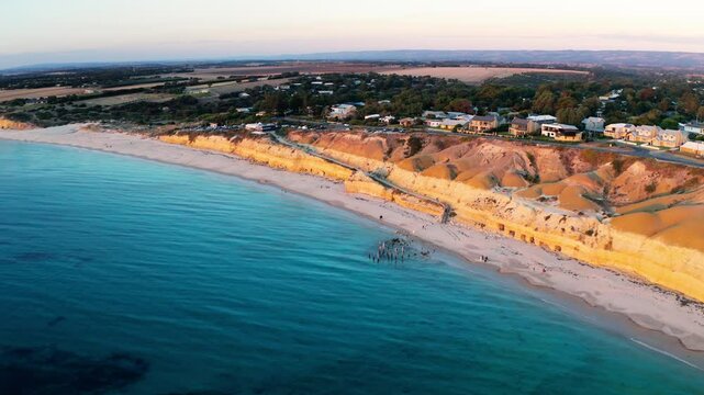 Aerial view of beautiful cliffs and sandy beach at sunset over the ocean, Port Willunga, Australia.