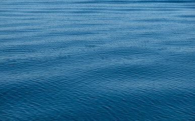 Ocean sea water surface calm with ripple, shades of blue background,