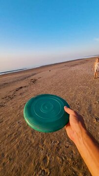 father and daughter playing frisbee on the beach
