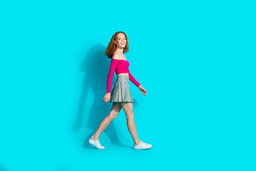 Full size photo of nice young girl walk empty space wear top isolated on teal color background