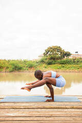 A beautiful young black woman practicing yoga outdoors in the countryside