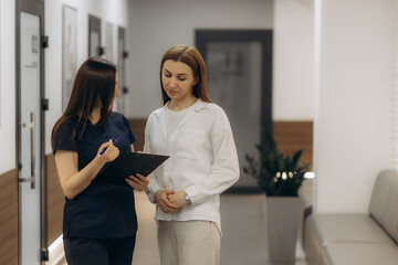A doctor and a patient talking in a hospital corridor