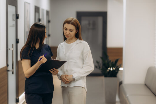 A doctor and a patient talking in a hospital corridor