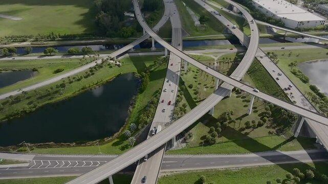 Aerial view of sawgrass interchange with modern highways and bridges surrounded by greenery and a canal, Davie, United States.