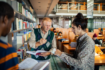 Professor helping students in the college library