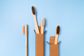 Eco-friendly dental wooden bamboo toothbrushes on plain blue background. Dental care and health, plastic-free life, zero waste, save the planet. Flat lay top view copy space