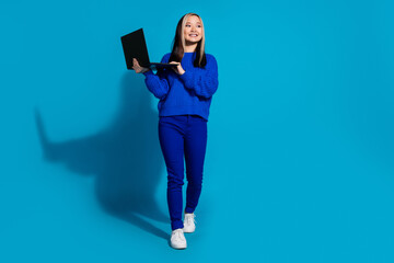 Portrait of japanese young girl with dyed brunette hair wear trendy outfit using laptop searching new job isolated on blue color background