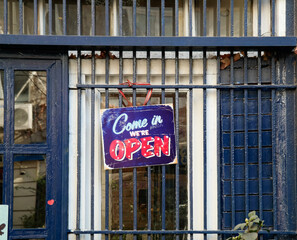 Sign saying "open" on the door of a coffee shop