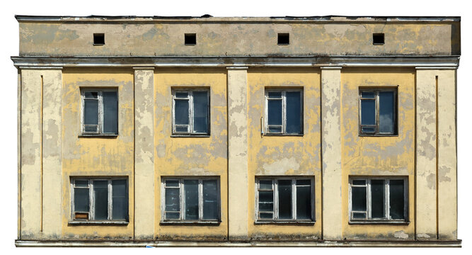 Destroyed wall of an old house with broken dirty windows isolated