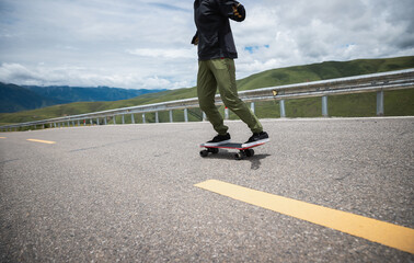 Skateboarder skateboarding on the mountain road