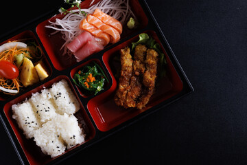 Tonkatsu and sashimi bento set japanese food isolate in black background