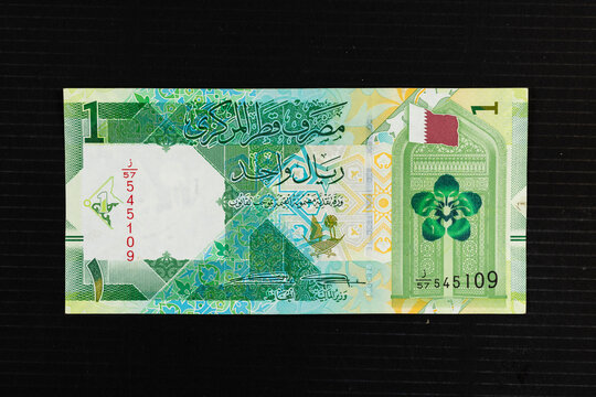 Traditional geometric patterns, flag of Qatar, flower ( Dreama ) and a gate representing historical Qatari architecture, Portrait from Qatar 1 riyal 2020 banknote.