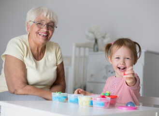 Grandmother and small girl making figures from play dough