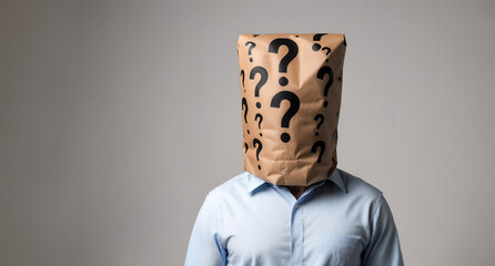 A person in a light blue shirt stands with a brown paper bag on their head, marked with question marks, suggesting anonymity or mystery.