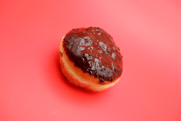 donut cake with chocolate topping on top. donut cake isolated on red background.