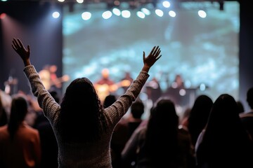 Hands in the air, people who are praising God and Jesus at a church service with worship band in...