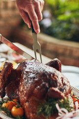 Hands, food and cutting turkey for thanksgiving celebration, festive holiday or serve buffet. People, dinner and carving meat in home at social gathering, event or eating closeup with knife and fork