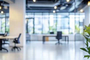 A modern office interior with blurred out desks and chairs, with a large window in the background and a potted plant in the foreground.