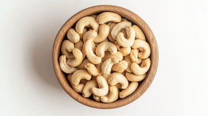 Fototapeta premium Cashew nuts neatly arranged in a wooden bowl, isolated on a white background, top-down view. Perfect for food advertising.