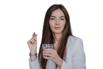young woman holding a glass of water and a capsule, dressed in a white blazer, with a serious expression against transparent background. Concept of health, wellness, and self-care