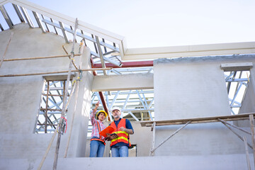 Blue collar workers are building house.