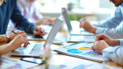 A group of professionals participating in a business skills workshop, with laptops and presentation materials