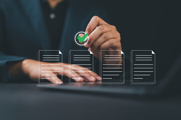 Hand using laptop computer with virtual screen and document for online approve paperless quality assurance and ERP management concept.