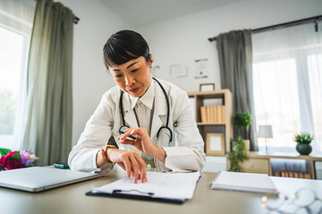 one woman mature japanese doctor work examine clipboard 