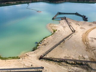 Aerial - drone view of Sand quarry with industrial structures and artificial lake.