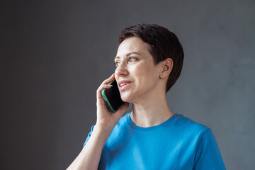 Stylish adult woman with short hair using smartphone.