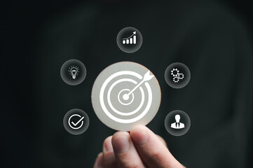 concept of business goals, strategy and planning for success, businessman hand holding circle stick with dart board icon, clearly shows the goals of the business with working systematically..