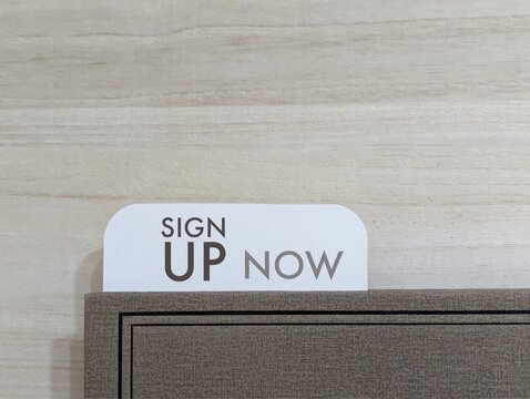 white paper and book with the words Sign Up Now. business and education concept