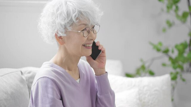 スマートフォンで通話しているシニア女性	
