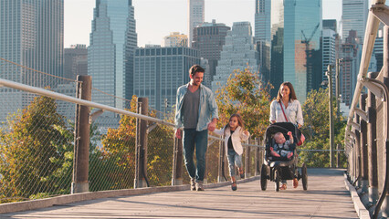 Family Day Out In New York City With Mum Pushing Baby In Buggy With Manhattan Skyline In Background