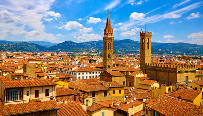 Fototapeta premium Towers of Palazzo Vecchio in Florence top view at tiled terracotta roofs old town. Blue mountains landscape on background. Firence, Italy.
