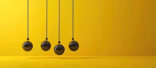 Newton s cradle against a yellow background with space for text The physics principle of energy conservation. Copy space image. Place for adding text and design