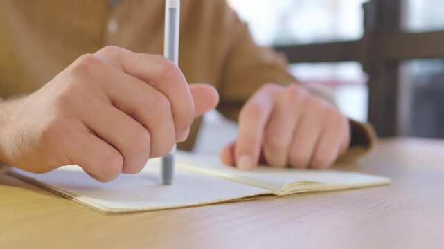 A man hands holding a pen, waiting for new ideas while brainstorming for a project. Ideal for themes of creativity, planning, and ideation