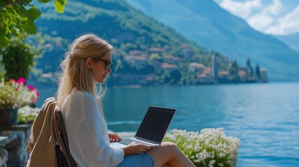 A happy digital nomad freelancer who work remotely from a laptop on the shores of Lake Como, Italy, in a flexible and active work environment with beautiful scenery. Replication space