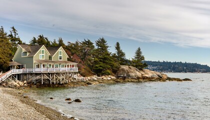 Casa de madera, con vistas al mar, de barandillas blancas y grandes ventanas