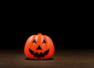 Halloween carved pumpkin jack o lantern with a smile on a wooden floor  black background.