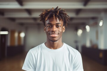 Fototapeta premium Portrait of a smiling male African American teenager in basketball gym