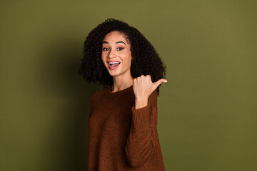 Fototapeta premium Portrait of pretty young woman point finger empty space wear sweater isolated on khaki color background