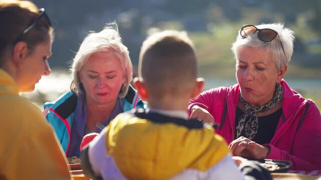 Caucasian Family Enjoying Traditional Turkish and Balkan Meal Borek by a Mountain Lake on a Sunny Day. Concept of Turkish Food, Lunch, Sharing, Delicious, Gastronomy, Cuisine, Tasty, Savory