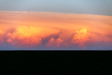 An incredible colorful sunset with cumulonimbus clouds illuminated by the sun.