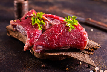 Raw meat with herbs and garlic, marble meat. Wooden background. Top view.